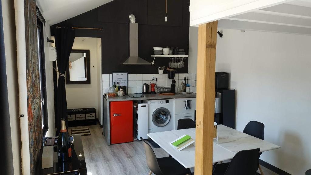 a kitchen with a table and a washing machine at Champagne Studio in Épernay