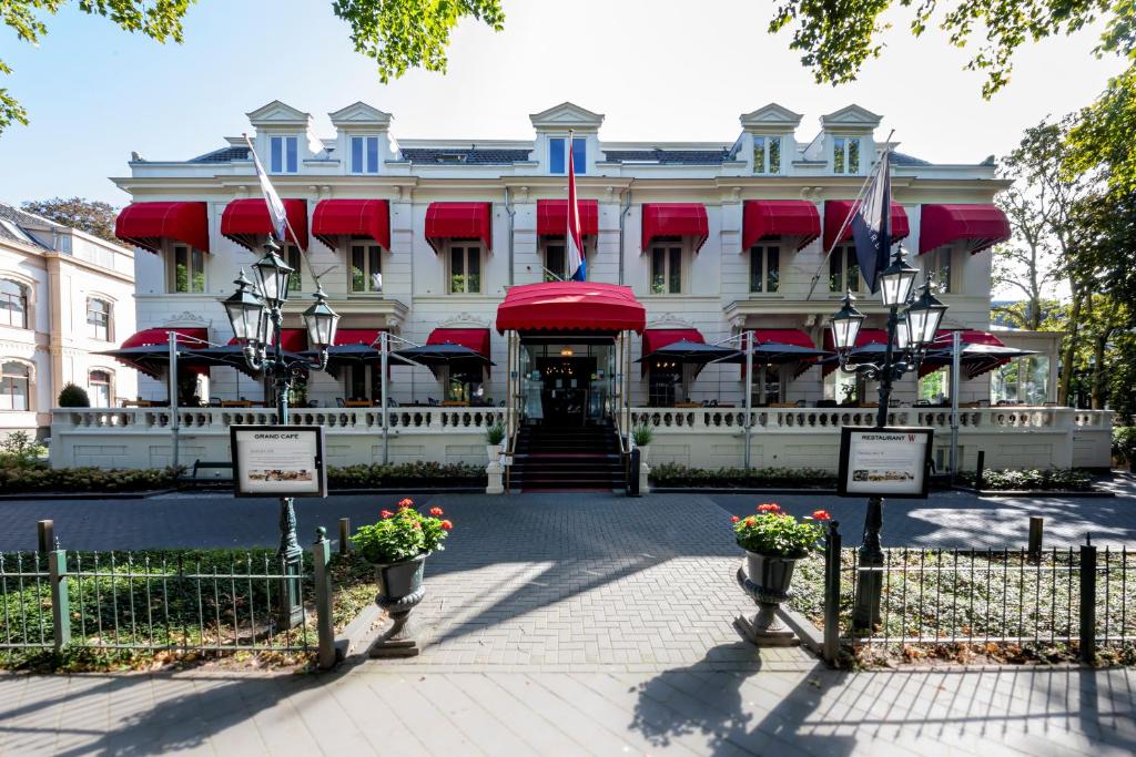 Un bâtiment avec des drapeaux à l'avant dans l'établissement Bilderberg Grand Hotel Wientjes, à Zwolle