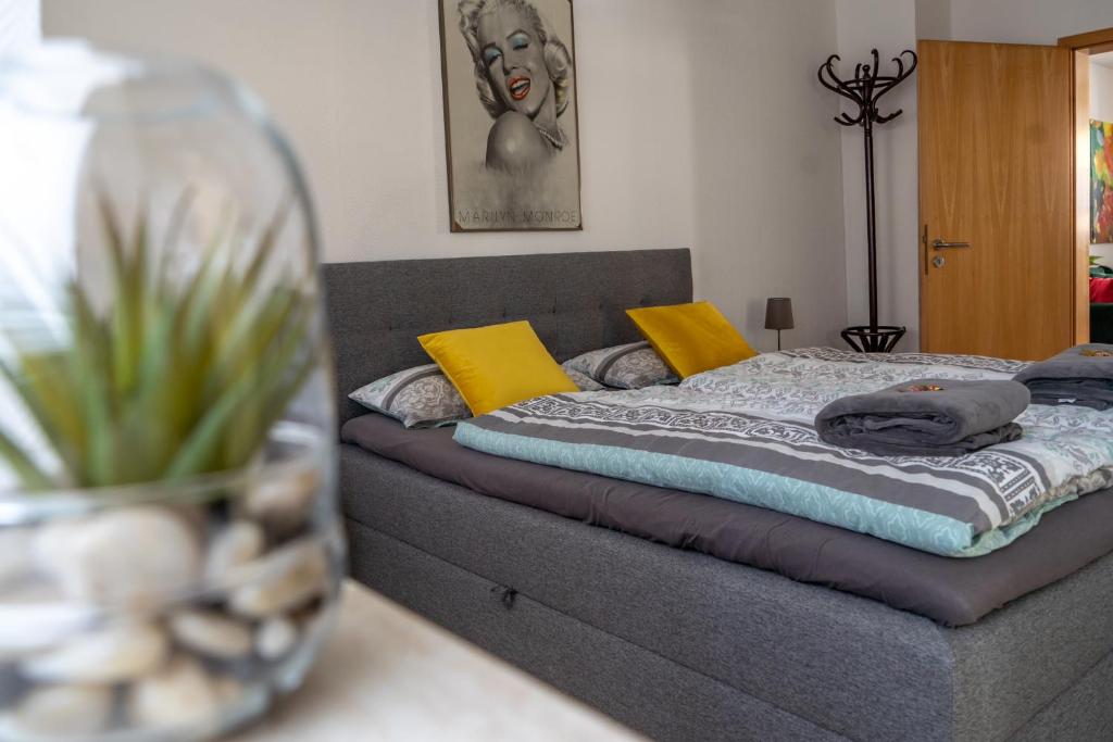 a bed with yellow and blue pillows in a room at Moderne Altstadt-Ferienwohnung in Hammelburg