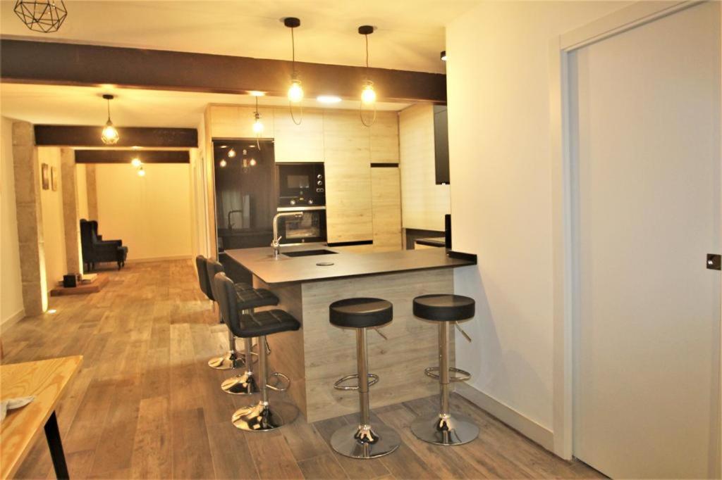 a kitchen with a counter and stools in a room at FH ALTEA CENTRO PLAYA in Altea