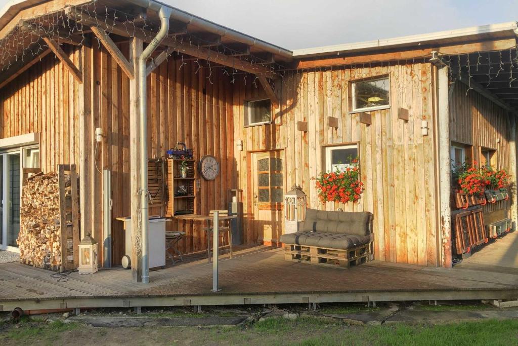 a wooden building with a chair on a deck at Ruegen Fewo 66 in Kasnevitz