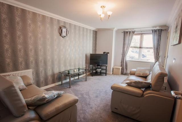a living room with a couch and a tv at 2 Bed Blackburn Village Apt With Wifi & Parking in Aberdeen