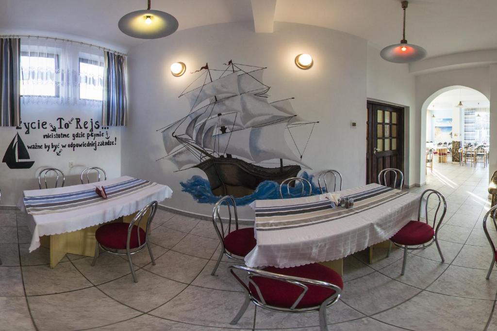 uma sala com duas mesas e um navio pirata na parede em Zibi i Pod Topolami em Łazy