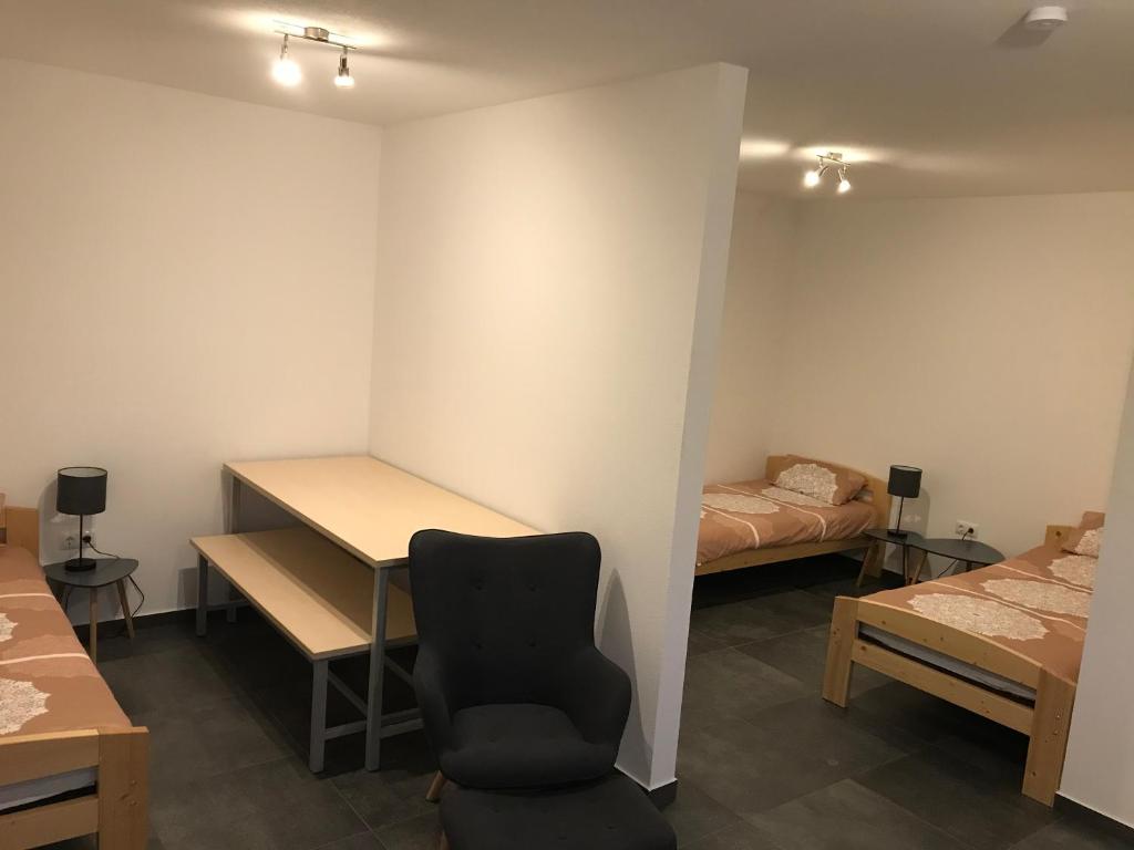 Habitación con escritorio, silla y cama. en Monteurwohnung 1, en Ingelheim am Rhein