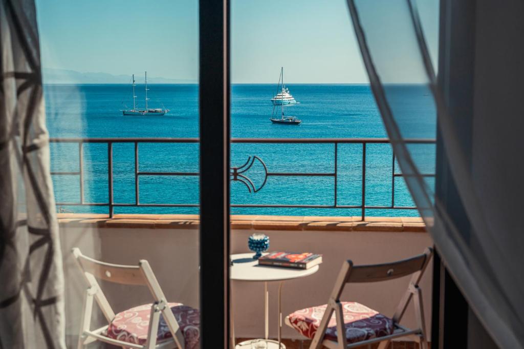 a view of the ocean from a balcony with a table and chairs at B&B Marranzano in Giardini Naxos