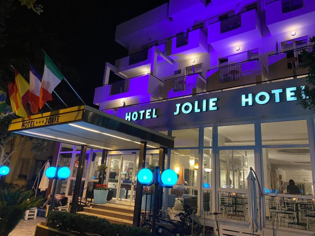 a hotel with purple lights in front of a building at Hotel Jolie in Rimini