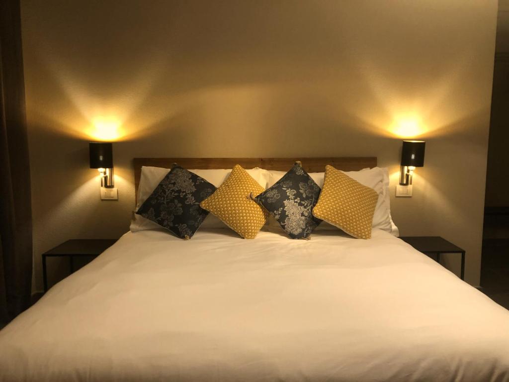 een bed met gele en zwarte kussens erop bij Rooms Da Steu in Barbaresco