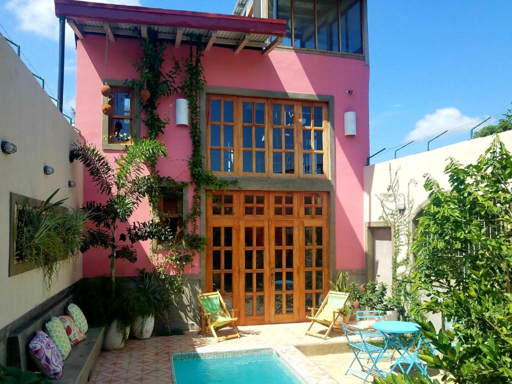 a pink house with a pool in front of it at Secret Cottage Granada Nicaragua in Granada