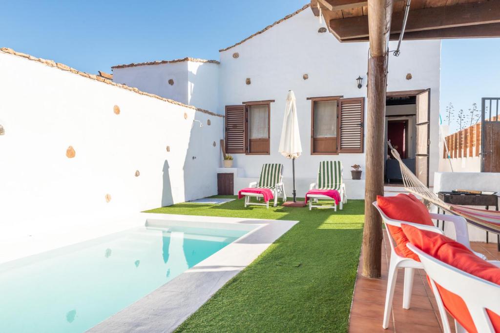 ein Haus mit einem Pool und einer Terrasse mit Stühlen in der Unterkunft Casa la Orilla in Antigua