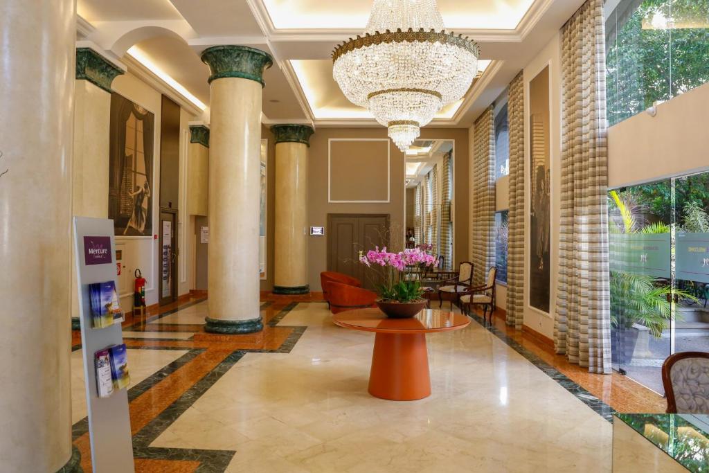 a lobby with a chandelier and a table and chairs at Flat INCRIVEL na Vila Olimpia in Sao Paulo
