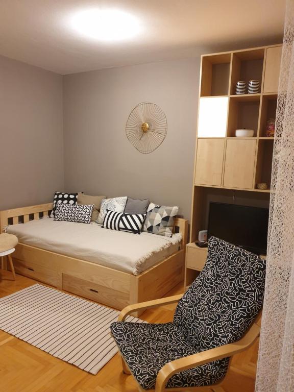 a small bedroom with a bed and a chair at Stan na dan "Irina" Banja Luka in Banja Luka