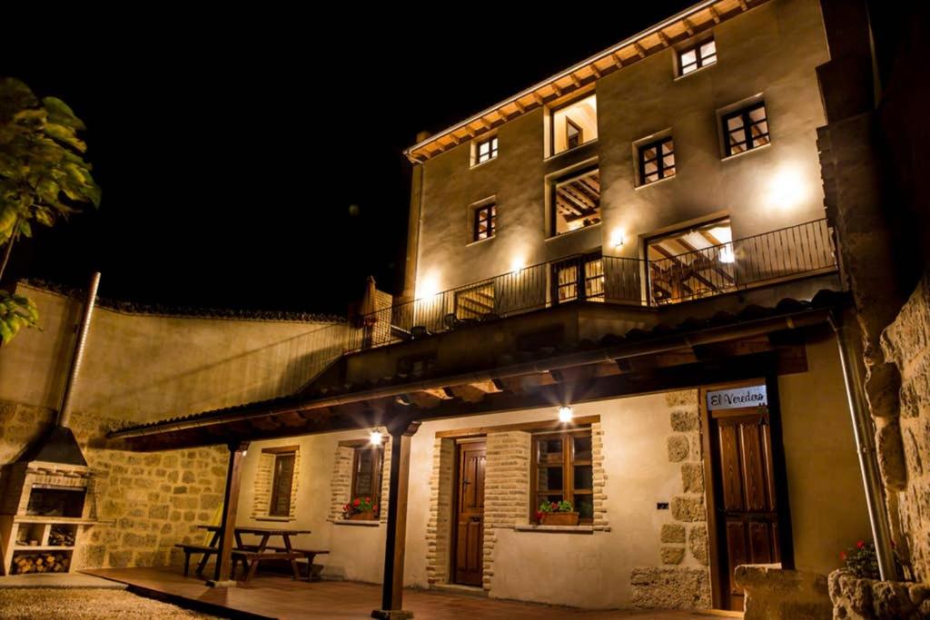 a building with a balcony and a table in front of it at Casa rural El Veredero in Castrojeriz