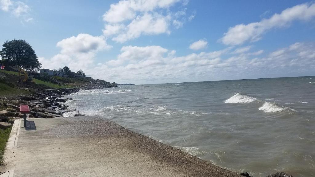 a body of water next to a wooden walkway at Lake View Cottage on Lake Erie in Ashtabula