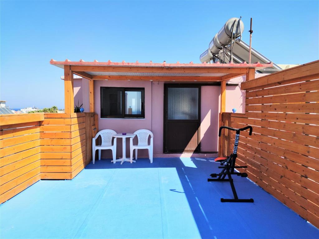 een patio met een tafel en stoelen op een huis bij 7. Luxurious sea view rooftop suite in the center! in Rhodos-stad