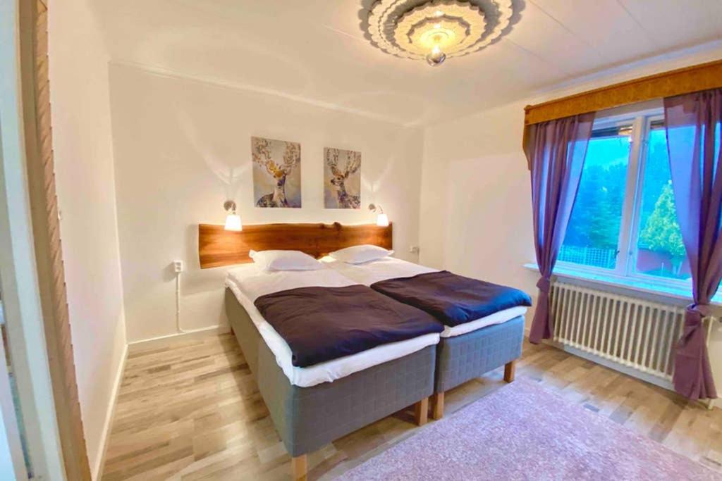 1 dormitorio con cama y ventana grande en Apartment Delux Vaggeryd near nature, en Vaggeryd