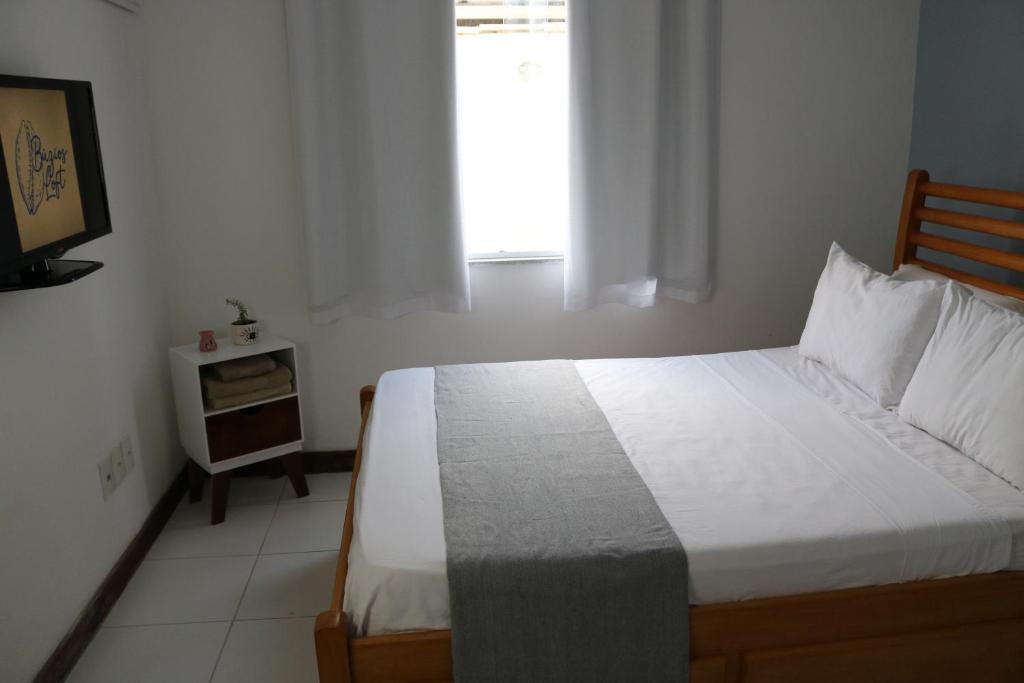 a bedroom with a bed and a window at Búzios Lofts in Búzios