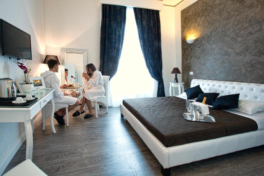 dos personas sentadas en una mesa en una habitación de hotel en Rome Key Home, en Roma