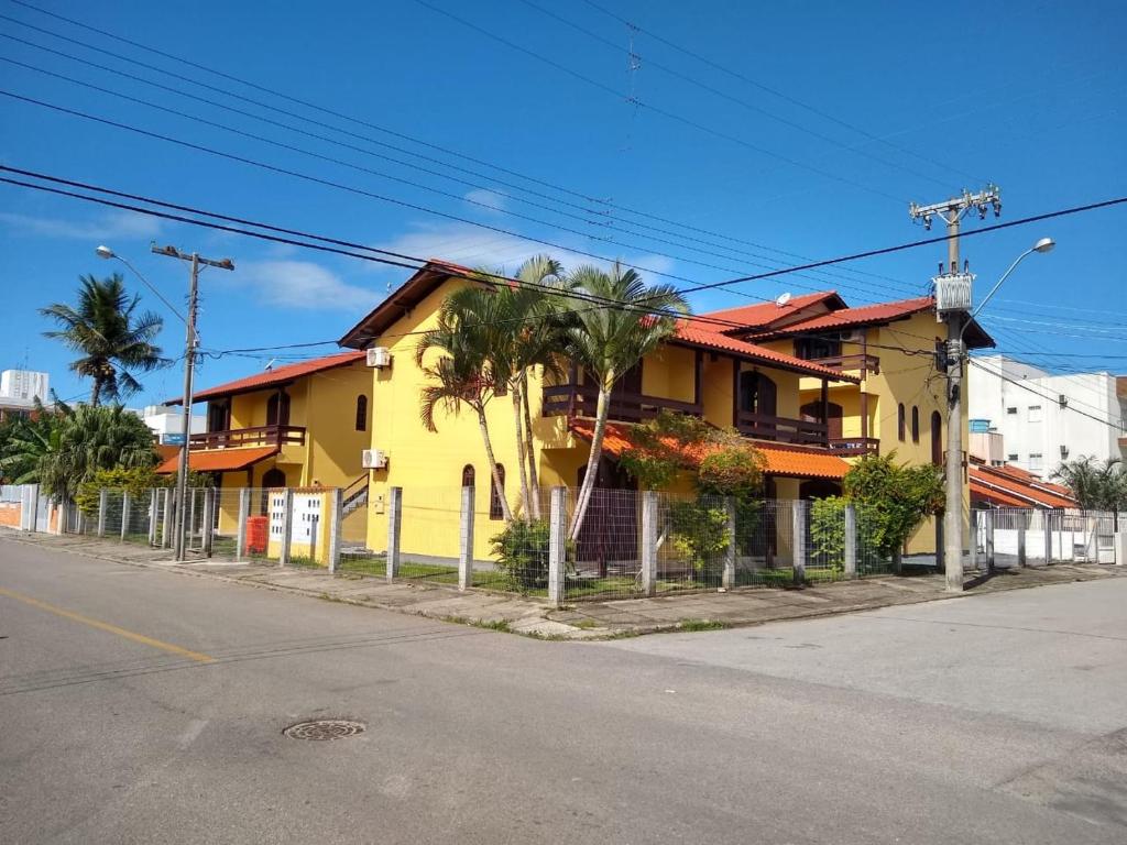uma casa amarela ao lado de uma rua em Residencial Vó Maria em Florianópolis