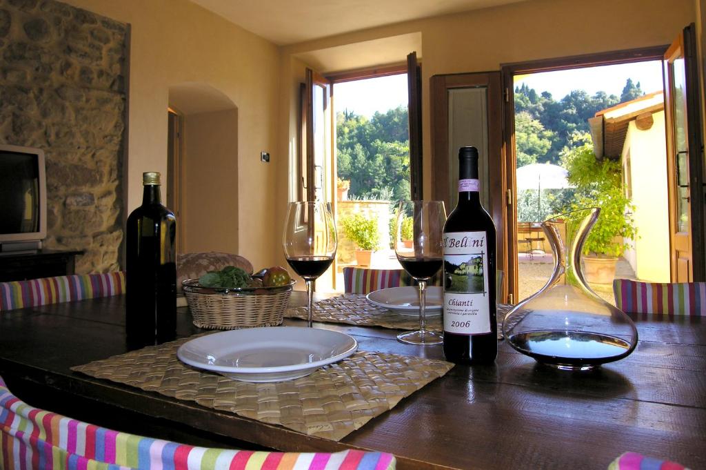 zwei Flaschen Wein und zwei Gläser auf dem Tisch. in der Unterkunft Comfortable apartment in the heart of the Tuscan countryside in Pulicciano