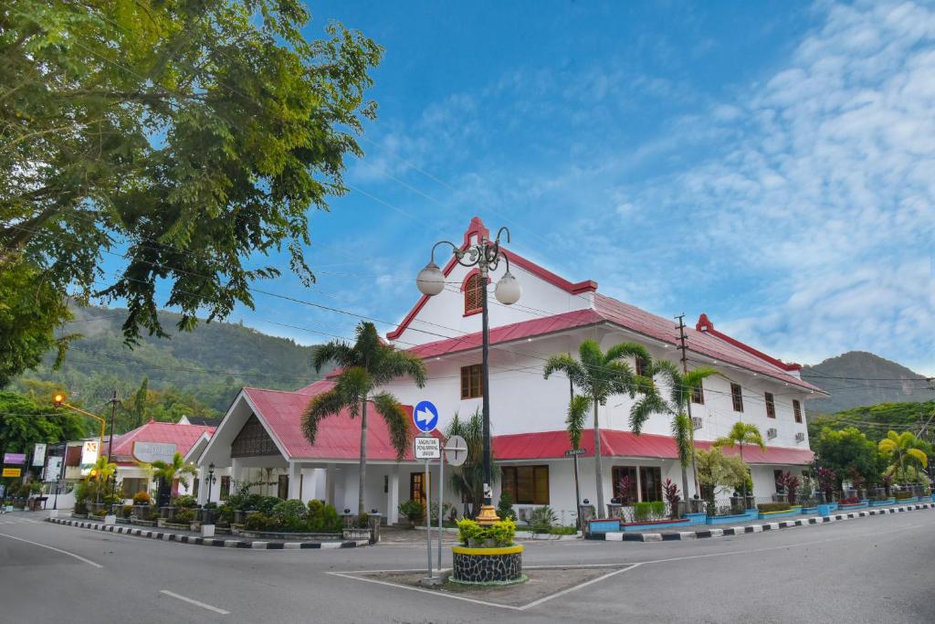 un bâtiment avec un toit rouge dans une rue dans l'établissement KHAS Ombilin Hotel, à Sawahlunto