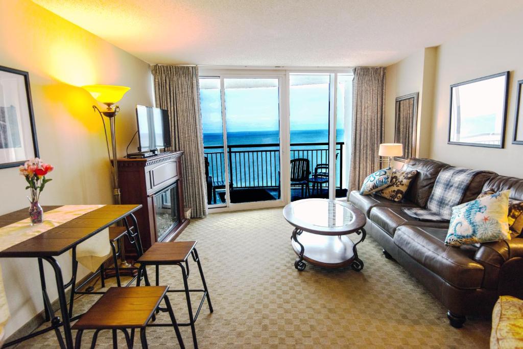 a living room with a couch and a view of the ocean at Deluxe Ocean front One Bedroom suite in Sandy Beach Resort in Myrtle Beach