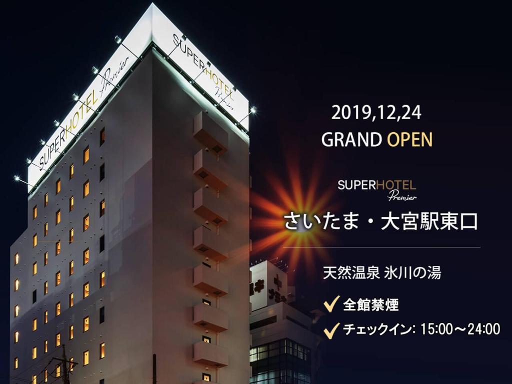 a building with a sign that reads grand open at Super Hotel Premier Saitama Higashiguchi in Saitama