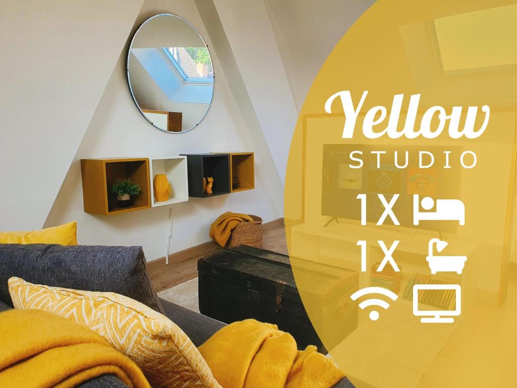 a living room with a yellow couch and a mirror at Yellow Studio in Mons