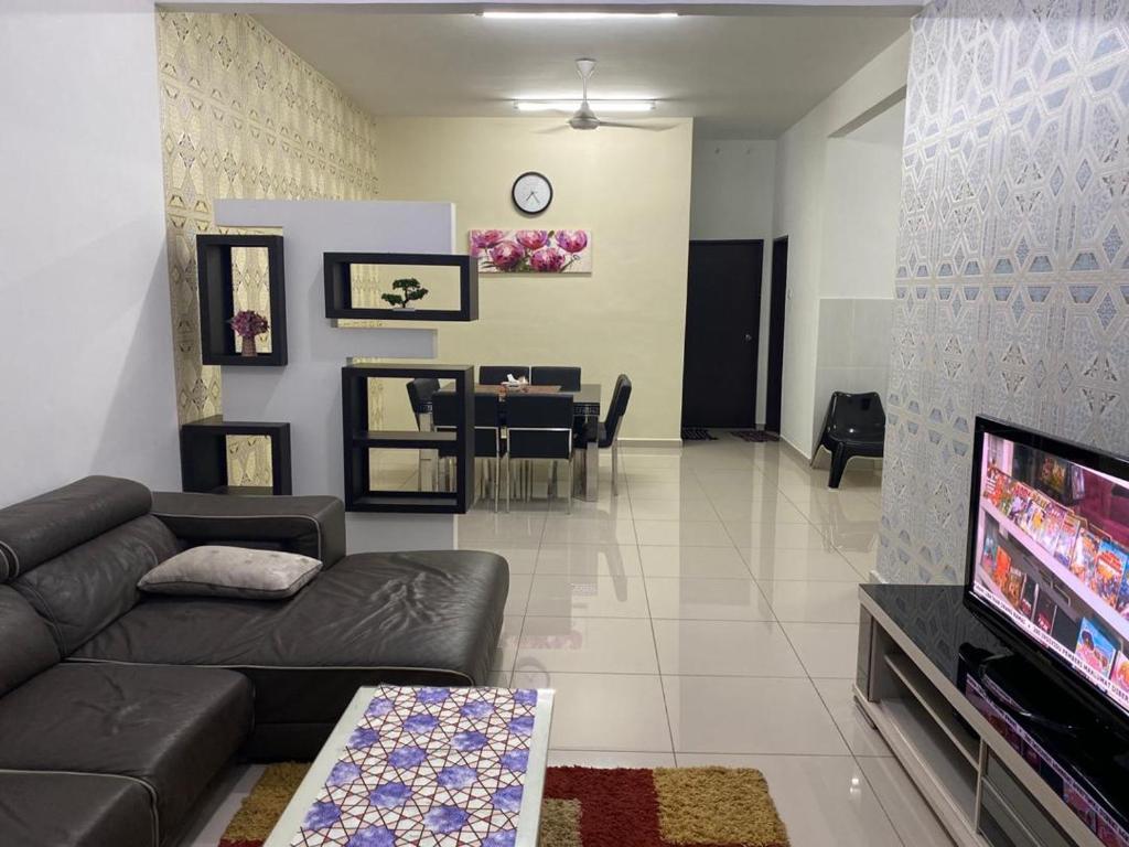 uma sala de estar com um sofá e uma sala de jantar em Homestay ayer keroh mitc em Malaca