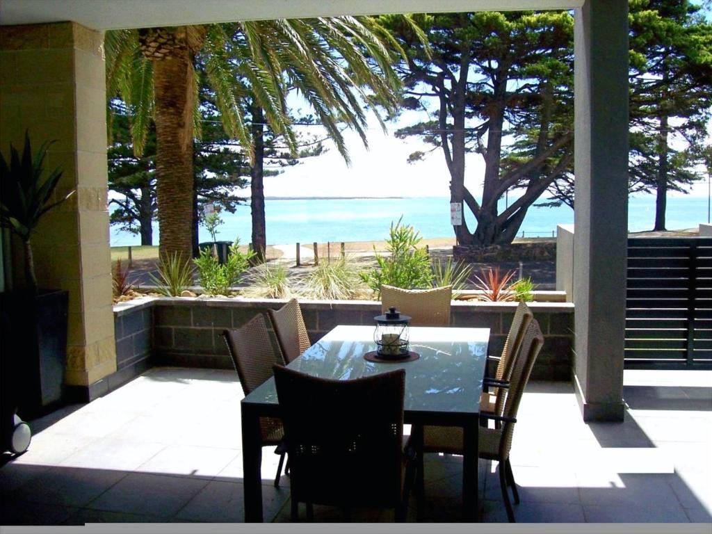 a table and chairs on a patio with a view of the ocean at C-Scape water front apartment in Cowes