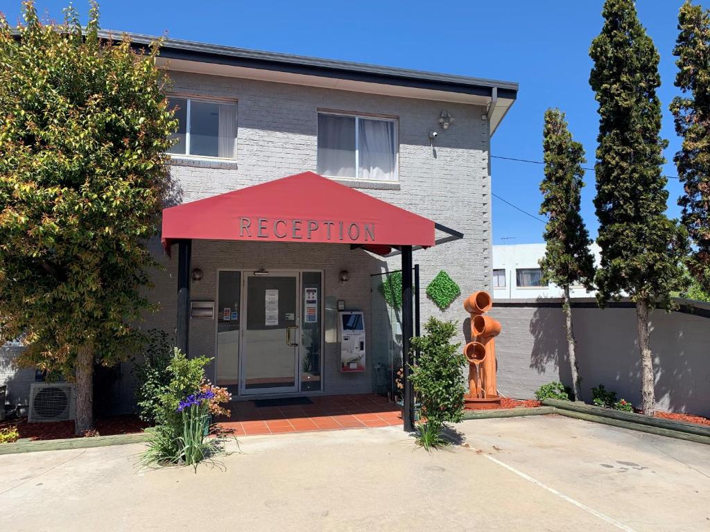 a building with a red awning in front of it at Crest Motor Inn in Queanbeyan