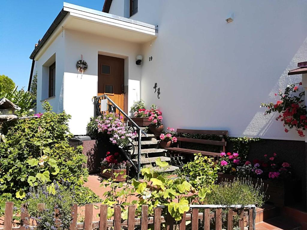 a small white house with stairs and flowers at Ferienwohnung und Bungalow Haegema in Eldena