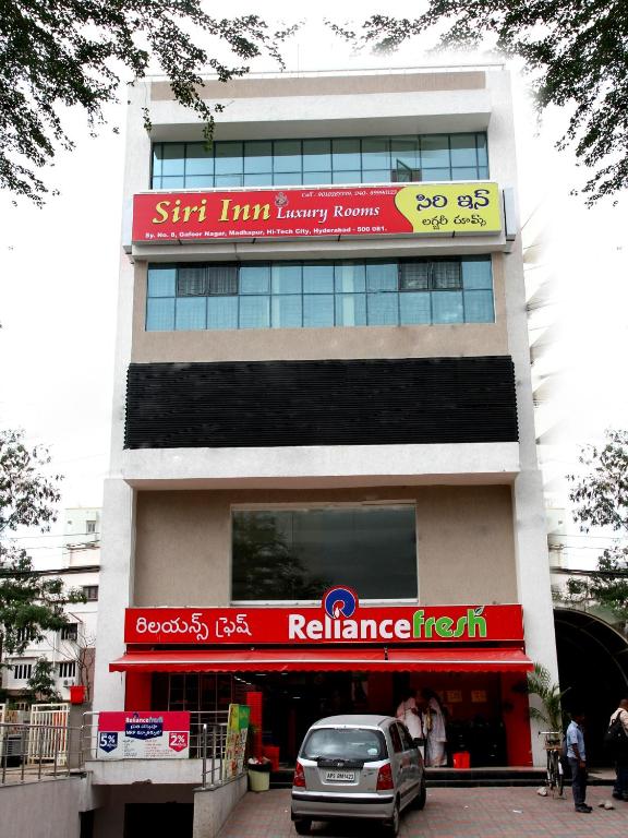 a building with a car parked in front of it at Hotel Siri Inn Hitech City in Hyderabad