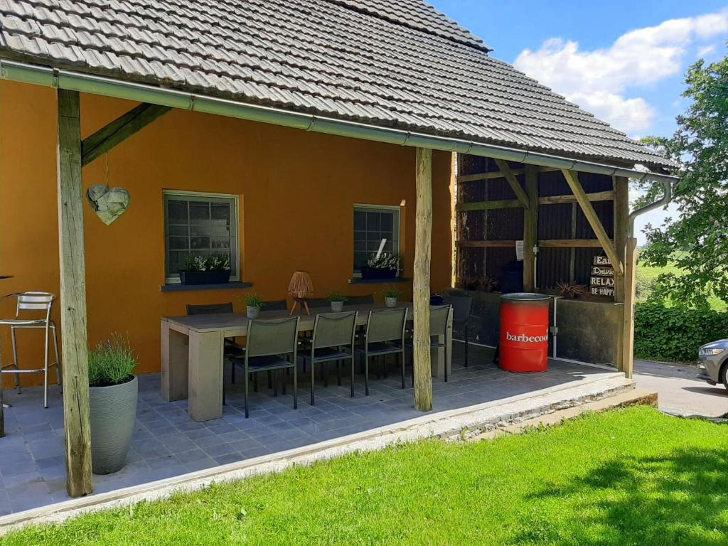 una casa con una mesa y sillas en un patio en Vakantiehuis De Lounge, en Büllingen