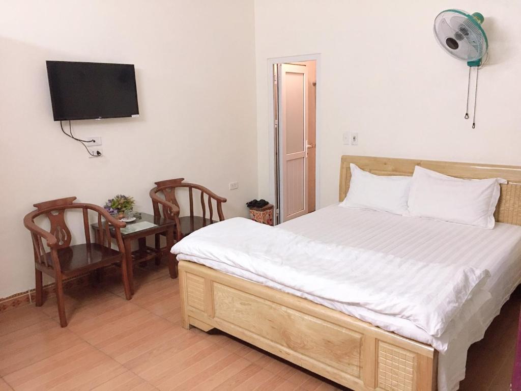 1 dormitorio con cama, mesa y TV en Nhà nghỉ hà anh 2 nội bài, en Noi Bai