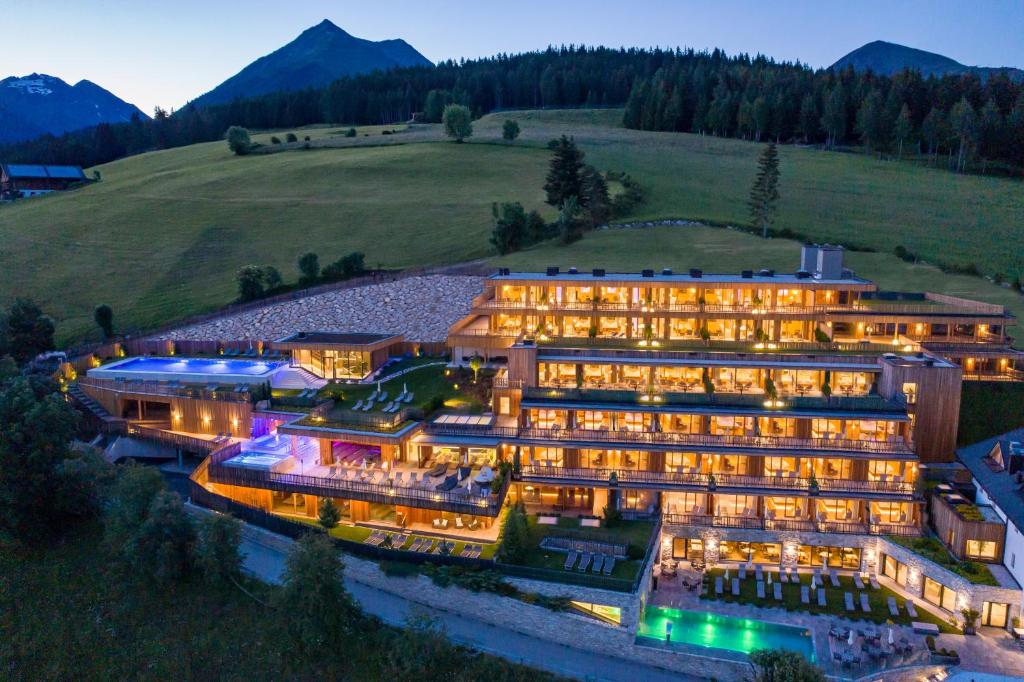 eine Luftansicht eines Hotels mit Bergen im Hintergrund in der Unterkunft Tratterhof Mountain Sky Hotel in Meransen