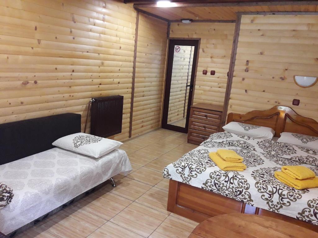 トリグラドにあるGuest House Chobakaのベッド2台 木製の壁の部屋