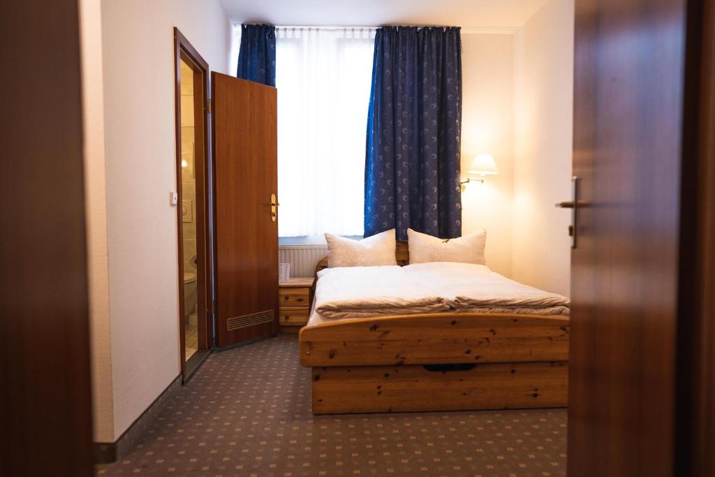 a small bedroom with a bed and a window at Pension am Heusteig in Stuttgart