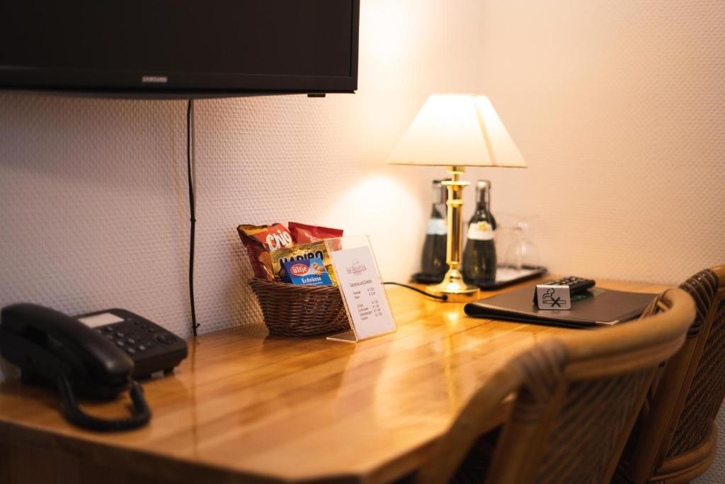 a table with a lamp and a telephone on it at Pension am Heusteig in Stuttgart