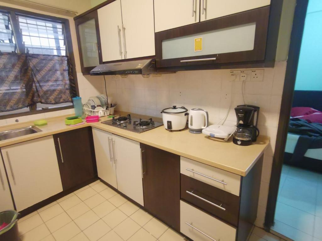 a small kitchen with a stove and a counter top at Cikgu Azue Homestay in Ampang