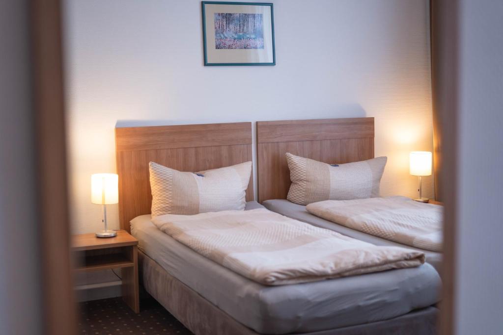 a hotel room with two beds and two lamps at Pension am Heusteig in Stuttgart
