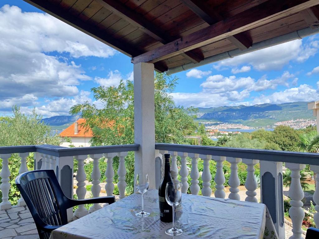 a table with two glasses of wine on a balcony at Apartments Horvat in Šilo