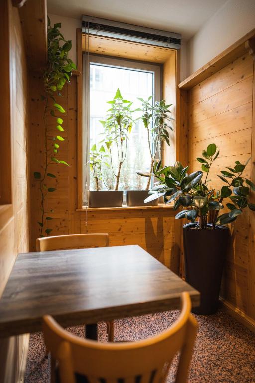 a wooden table and chairs in a room with a window at Pension am Heusteig in Stuttgart