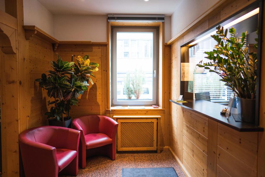 a room with two chairs and a window at Pension am Heusteig in Stuttgart