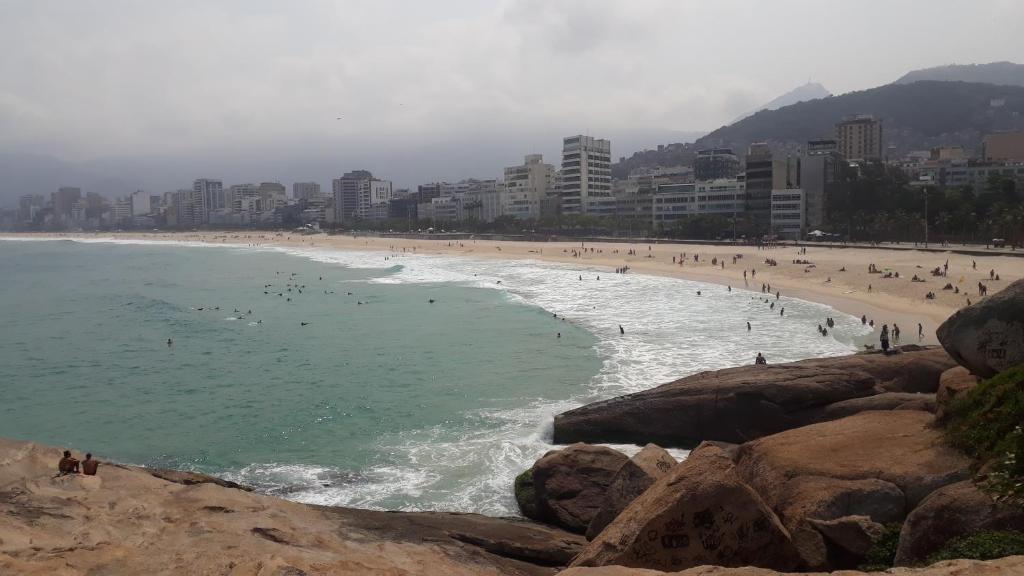 una playa con un montón de gente en el agua en Kitinete Ipanema, en Río de Janeiro