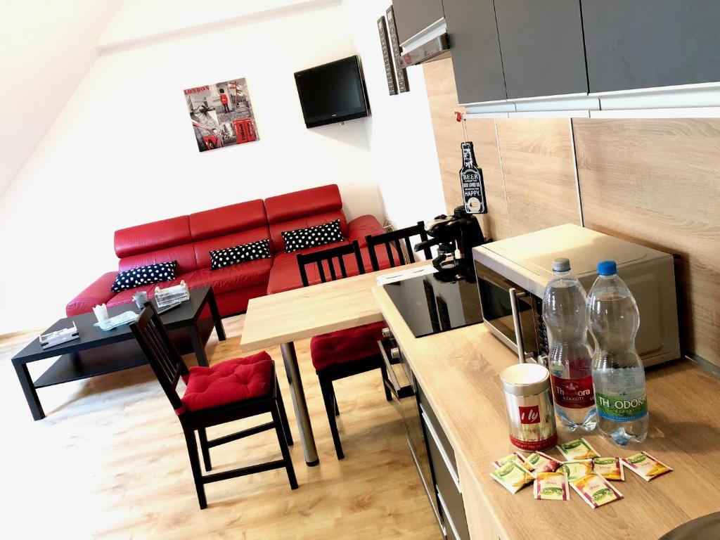 - une cuisine et une salle à manger avec des bouteilles de soda sur une table dans l'établissement City Center Apartman Miskolc, à Miskolc