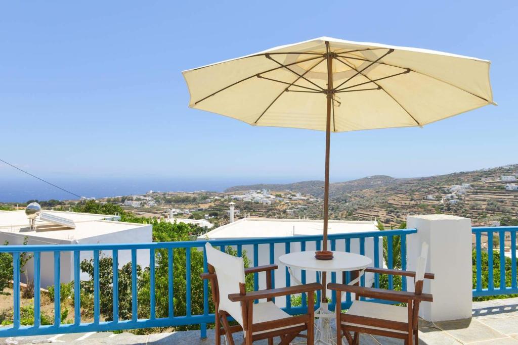 d'une table, de chaises et d'un parasol sur le balcon. dans l'établissement Kouki Maria Rooms, à Apollonia