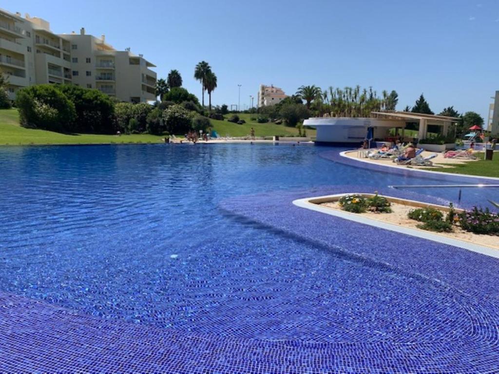a large blue swimming pool with blue water at Vila Marachique V Alvor in Alvor