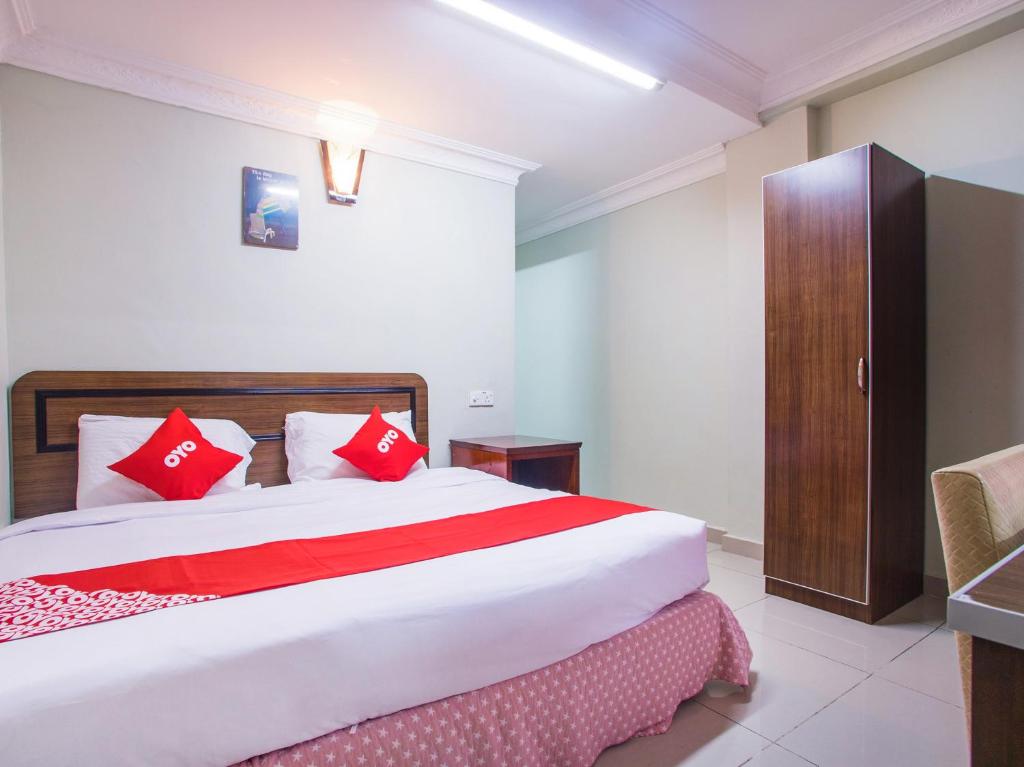 a bedroom with a large bed with red pillows at Super OYO 89363 Casavilla Hotel in Batu Caves