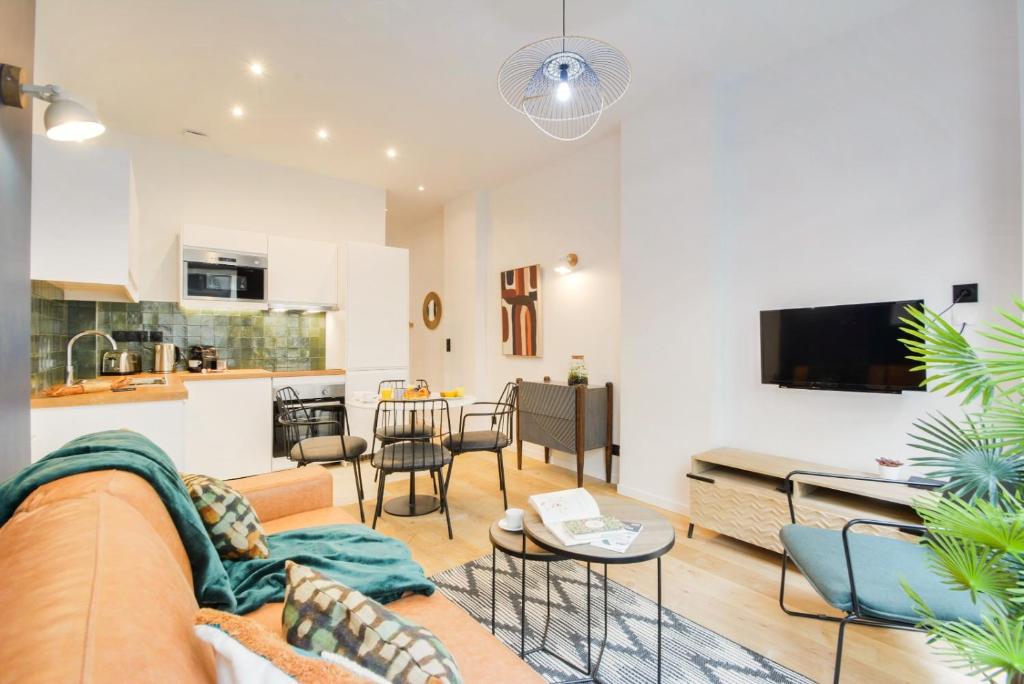 sala de estar con sofá, mesa y cocina en New and renovated amazing flat in heart of PARIS, en París