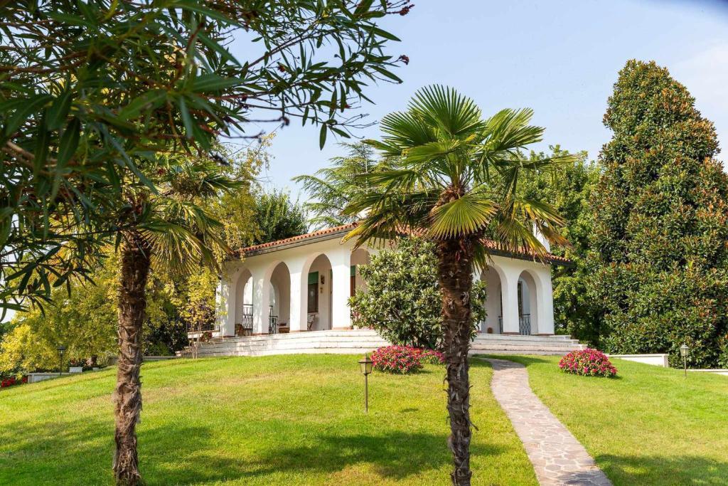 una casa con palmeras delante en Villa magnolia, en Cavallino-Treporti